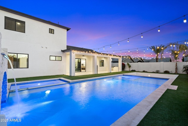 pool at dusk with a patio area