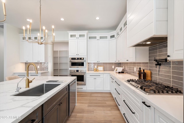 kitchen featuring sink, white cabinetry, a notable chandelier, and appliances with stainless steel finishes