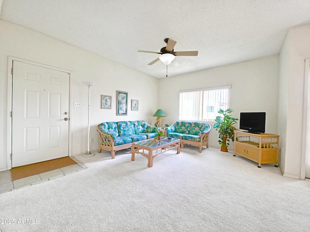 carpeted living area featuring a textured ceiling, a ceiling fan, and tile patterned floors