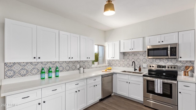 kitchen with appliances with stainless steel finishes, white cabinets, sink, and dark hardwood / wood-style flooring