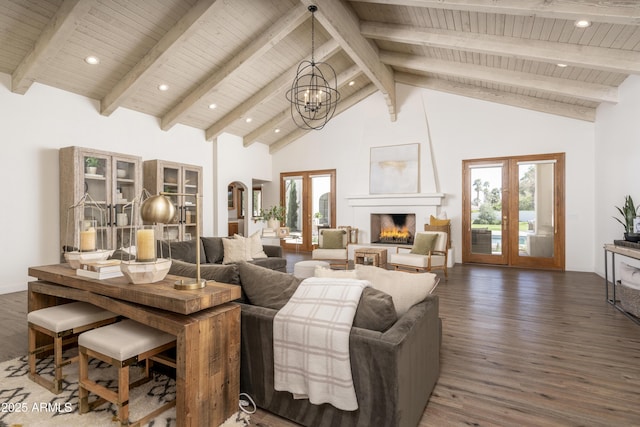 living room with a chandelier, french doors, a fireplace, wood finished floors, and high vaulted ceiling