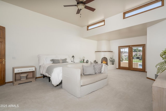 carpeted bedroom with a ceiling fan, access to exterior, a fireplace, and baseboards