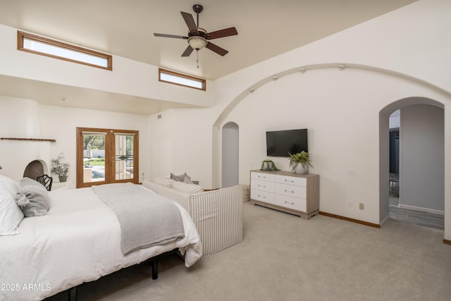 bedroom featuring baseboards, arched walkways, and carpet floors