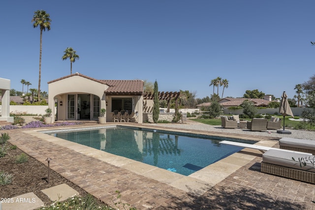 pool with a pergola, a patio, fence, outdoor lounge area, and a diving board