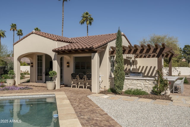 back of property with a patio area, outdoor dry bar, stucco siding, and a pergola