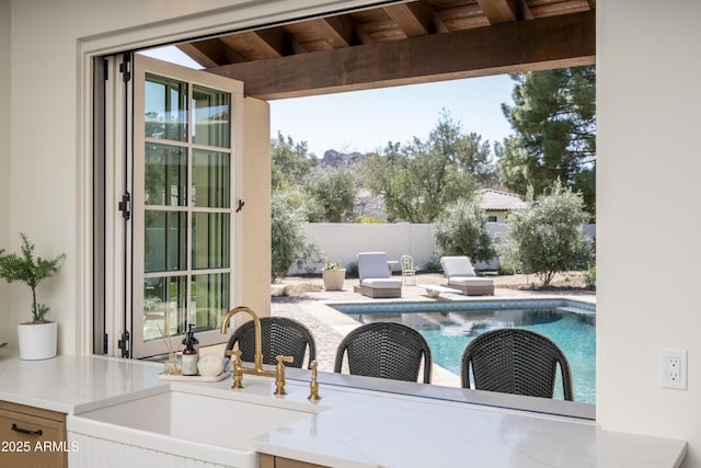 exterior space featuring outdoor dining space, a fenced in pool, fence, and a sink