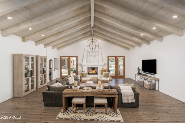 living room with french doors, a large fireplace, an inviting chandelier, and wood finished floors