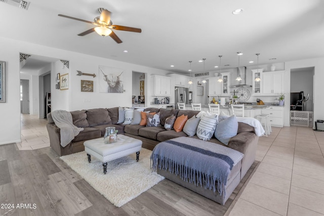 living room with ceiling fan and light wood-type flooring