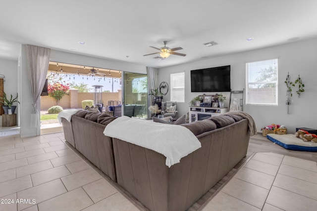 living room with ceiling fan, light tile floors, and plenty of natural light