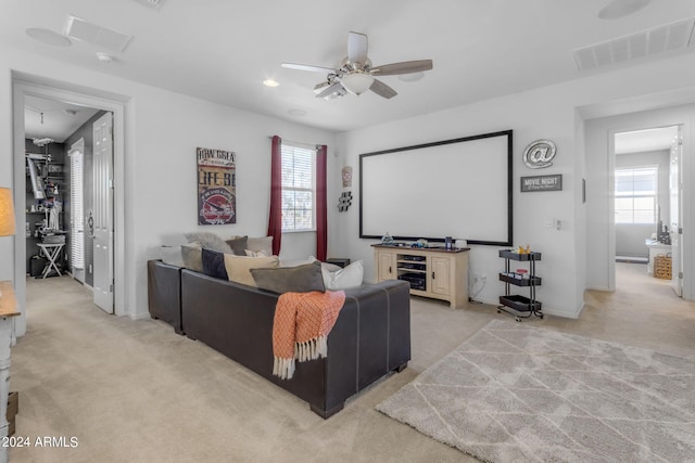 home theater featuring light colored carpet and ceiling fan