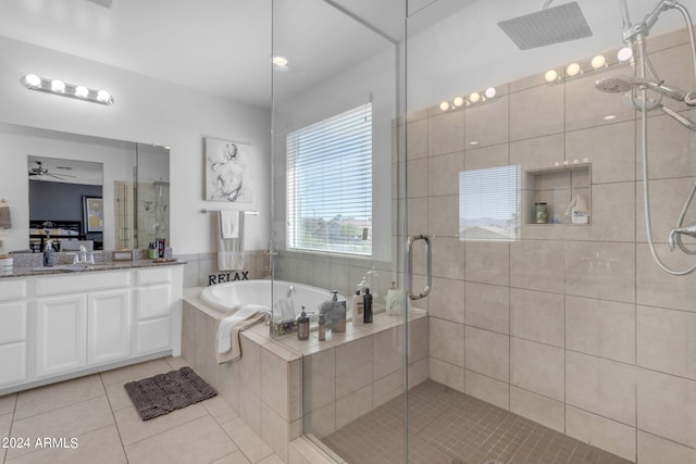 bathroom with plus walk in shower, ceiling fan, vanity, and tile flooring