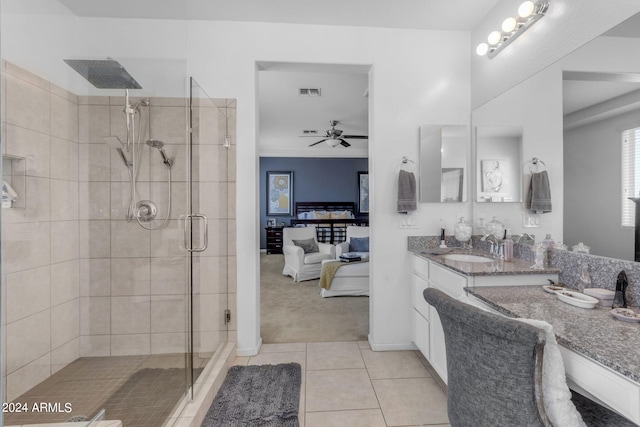 bathroom with vanity with extensive cabinet space, a shower with shower door, tile flooring, and ceiling fan