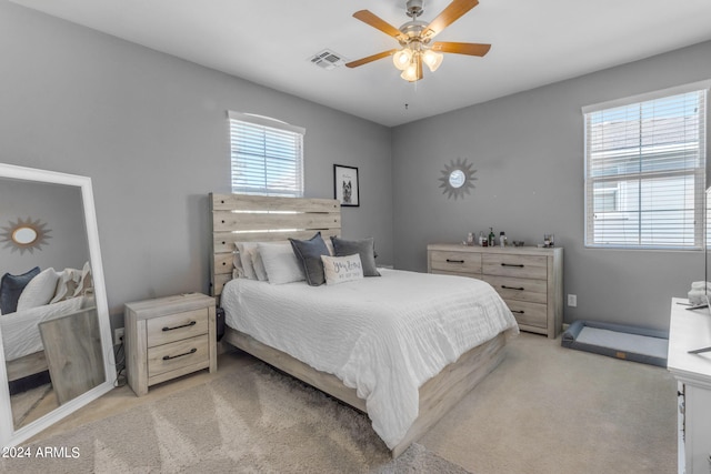 carpeted bedroom featuring ceiling fan and multiple windows