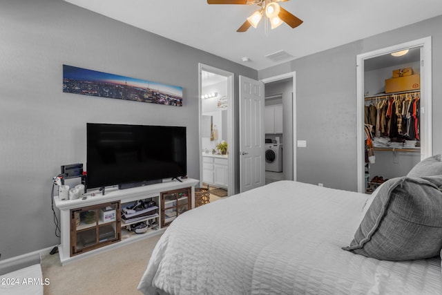 bedroom featuring a closet, connected bathroom, washer / dryer, light colored carpet, and ceiling fan