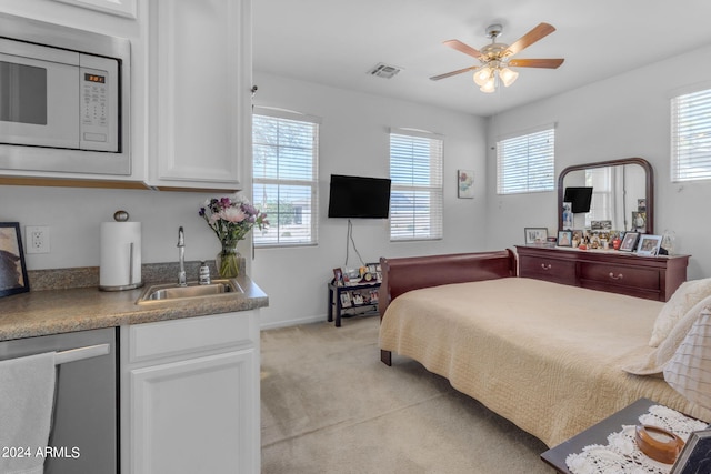 bedroom with light carpet, sink, and ceiling fan