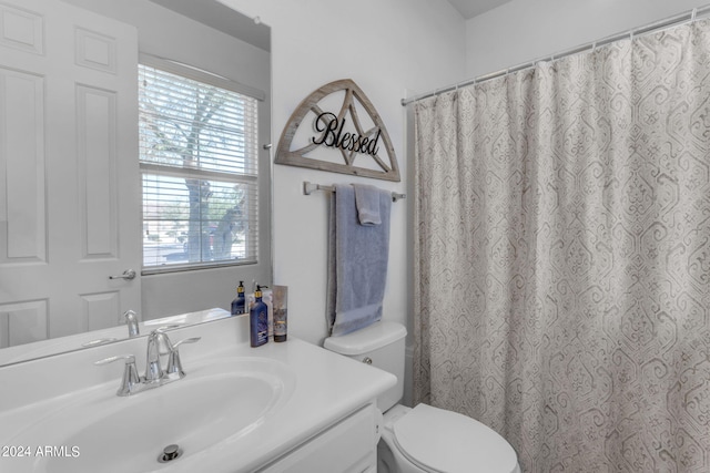 bathroom featuring a wealth of natural light, vanity, and toilet