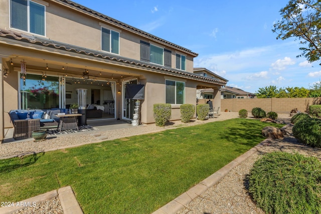 back of property featuring an outdoor living space, a yard, and a patio