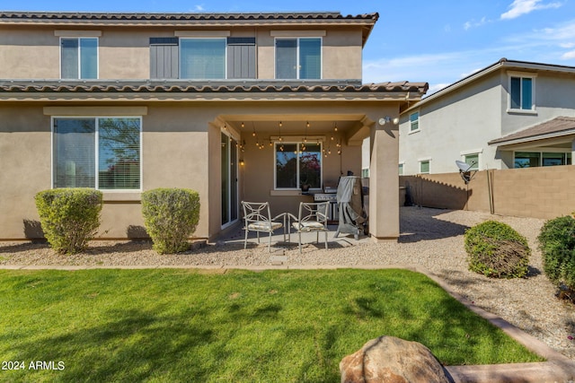 back of property with a patio and a yard