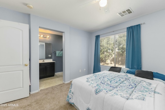 carpeted bedroom with ceiling fan and ensuite bathroom