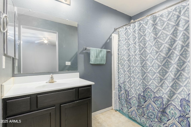 bathroom featuring ceiling fan, vanity, and walk in shower