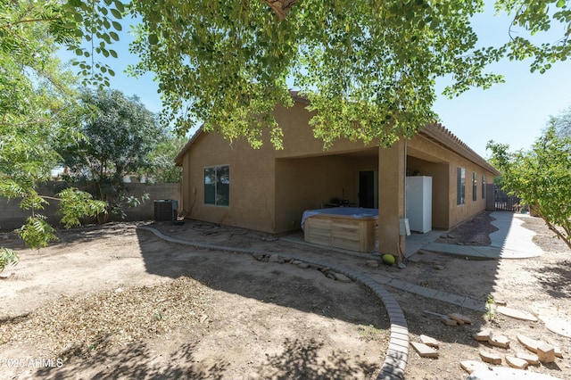 rear view of property with central AC