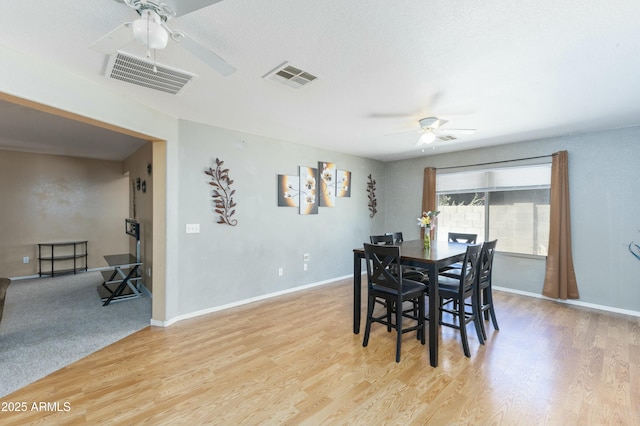 dining room with ceiling fan, a textured ceiling, and light hardwood / wood-style flooring