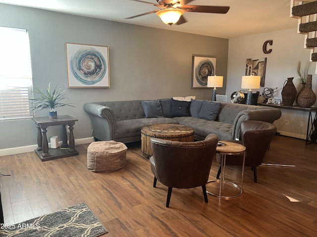 living area featuring ceiling fan, baseboards, and wood finished floors