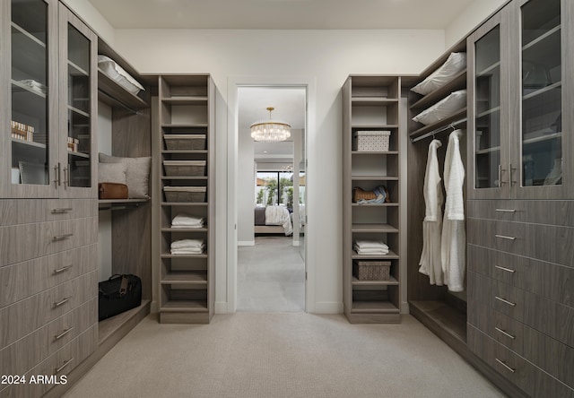 spacious closet featuring a notable chandelier and carpet flooring