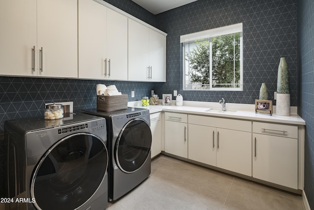 laundry room featuring a sink, cabinet space, independent washer and dryer, and light tile patterned floors