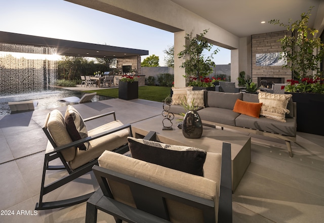 view of patio / terrace featuring fence, outdoor dining space, and an outdoor living space with a fireplace