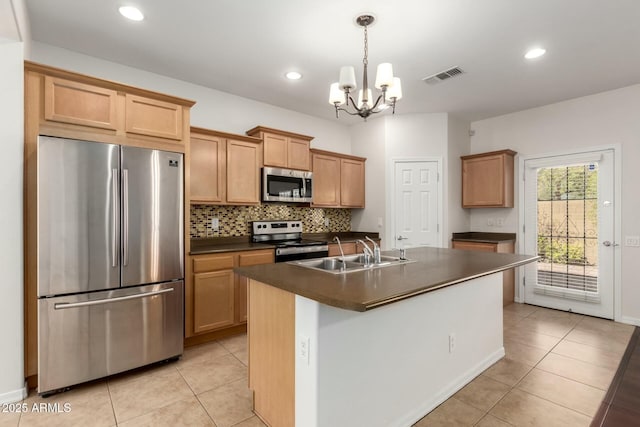 kitchen with light tile patterned floors, visible vents, a sink, stainless steel appliances, and dark countertops