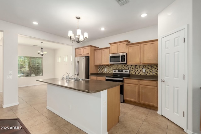 kitchen with dark countertops, tasteful backsplash, a chandelier, light tile patterned floors, and stainless steel appliances