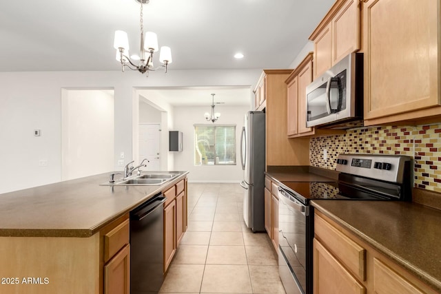 kitchen featuring stainless steel appliances, a notable chandelier, and dark countertops