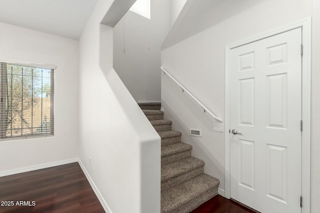 staircase with baseboards and wood finished floors