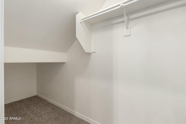 walk in closet featuring dark colored carpet and vaulted ceiling