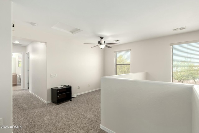 hall with baseboards, visible vents, attic access, and carpet