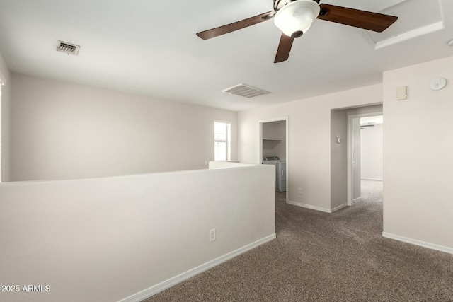 empty room with carpet flooring, washing machine and dryer, visible vents, and baseboards