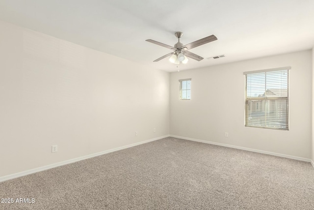 unfurnished room with a ceiling fan, carpet, visible vents, and baseboards