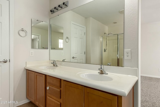 full bath with double vanity, baseboards, a stall shower, and a sink