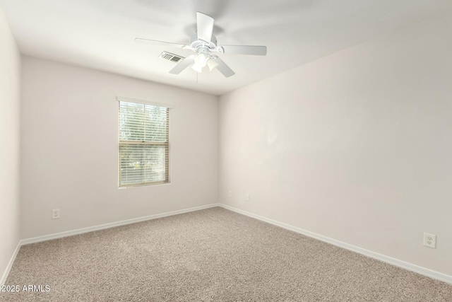 spare room with visible vents, carpet flooring, baseboards, and ceiling fan