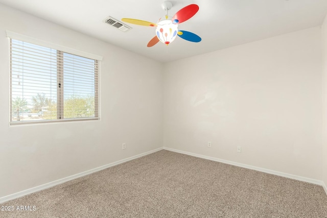 spare room with visible vents, carpet floors, baseboards, and a ceiling fan