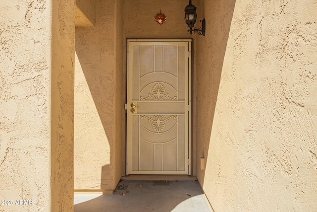 view of exterior entry with stucco siding