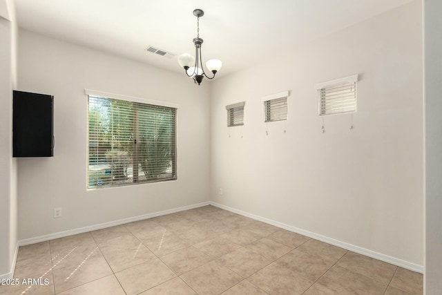 unfurnished room with light tile patterned flooring, baseboards, visible vents, and a chandelier