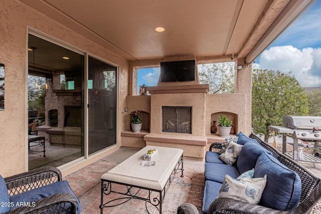 view of patio with an outdoor living space with a fireplace and a grill