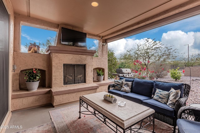 view of patio / terrace with an outdoor living space with a fireplace and grilling area