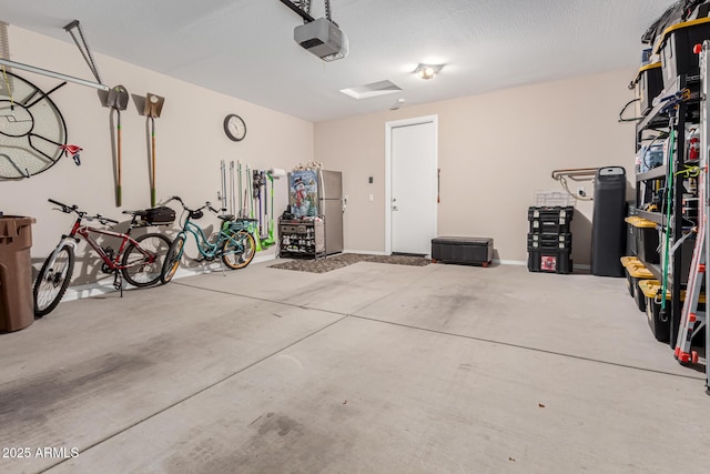 garage featuring stainless steel fridge and a garage door opener