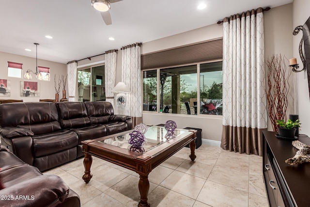 living room featuring ceiling fan with notable chandelier and a healthy amount of sunlight