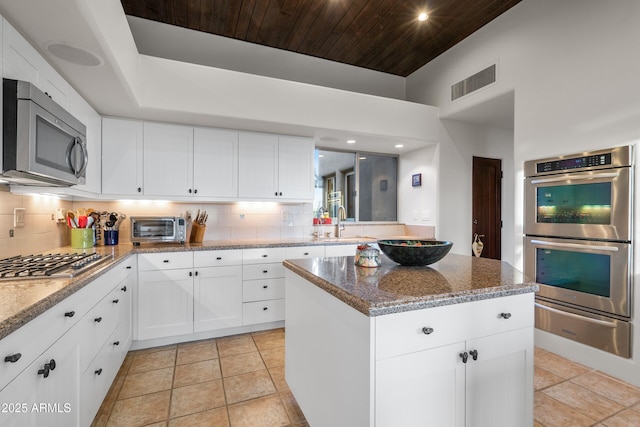 kitchen with a warming drawer, stainless steel appliances, backsplash, and visible vents