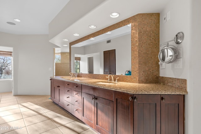 full bathroom featuring tile patterned flooring, visible vents, decorative backsplash, and a sink