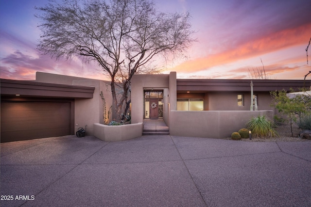 view of front facade with driveway and stucco siding